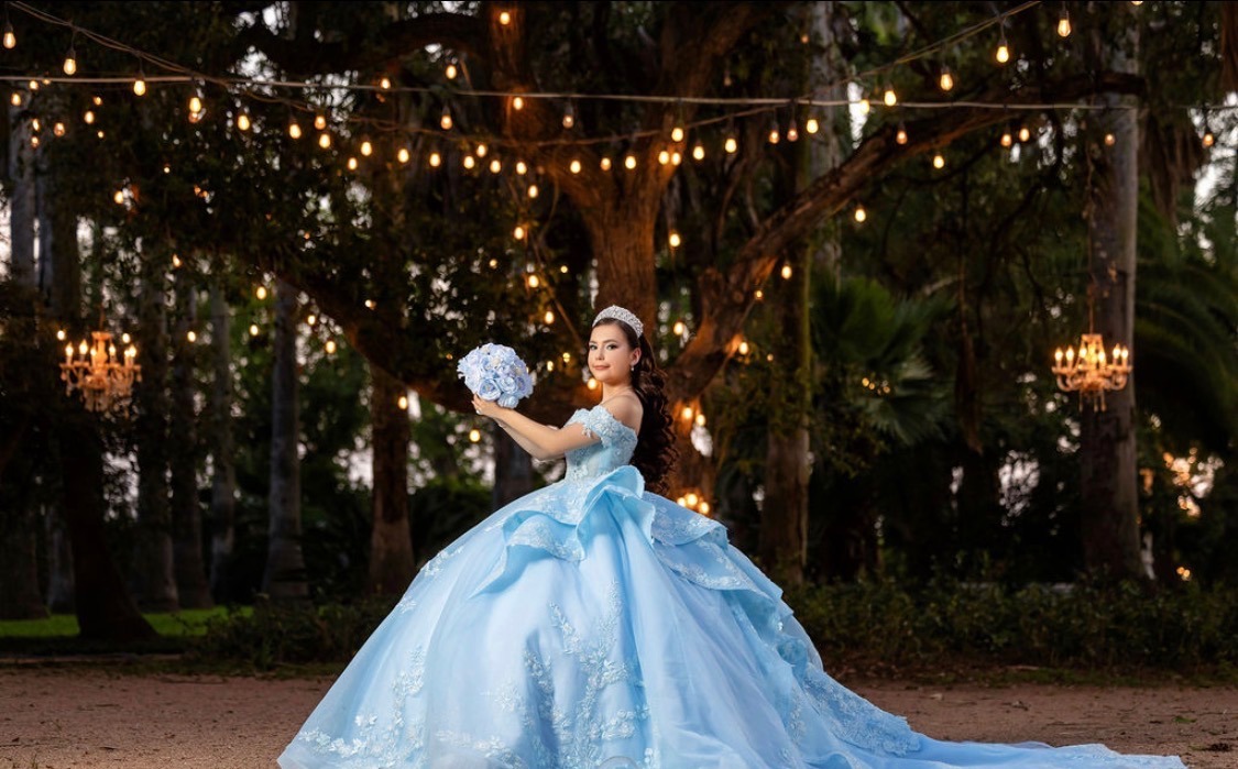 Carolina lifting her bouquet beneath lantern-lit trees